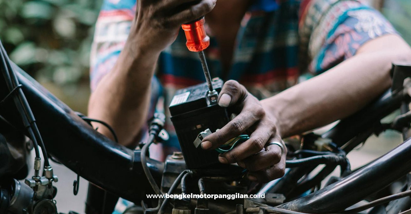 Montir memeriksa sistem kelistrikan motor